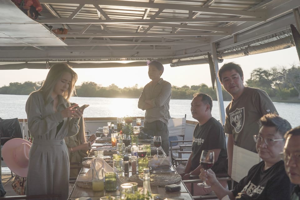 ผู้ร่วมเดินทางรับประทานอาหารบนเรือยามพระอาทิตย์ตก